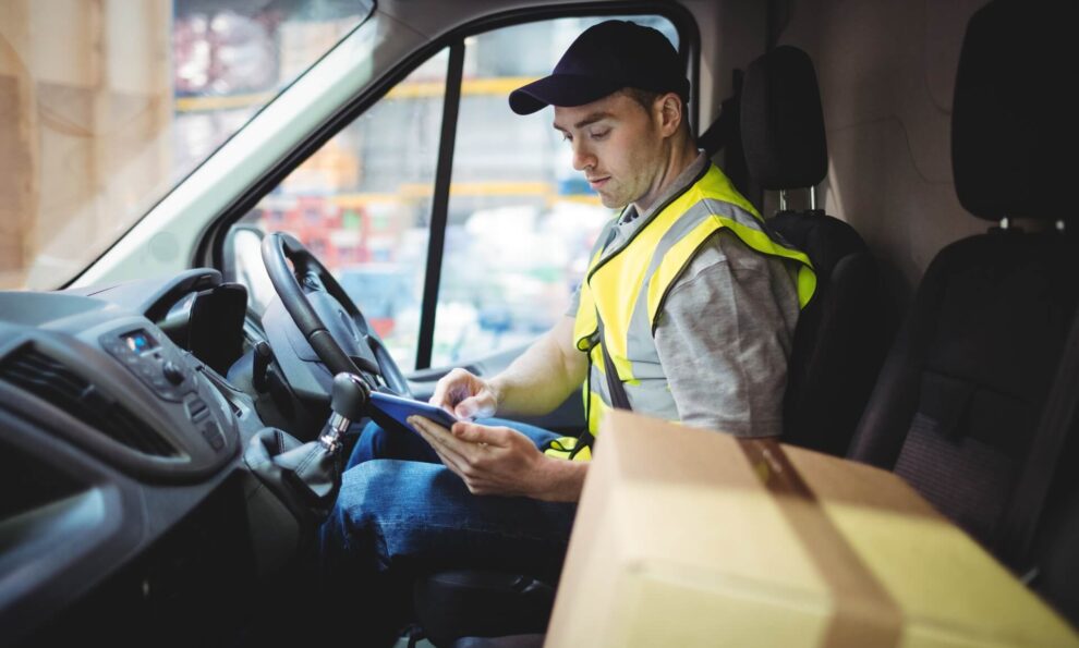 Delivery driver in truck using tablet